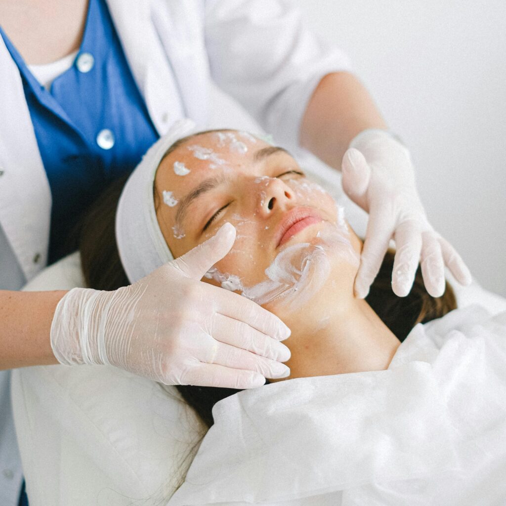 pexels-photo-5069494-5069494 From above of crop faceless cosmetician applying facial mask on customer face during cosmetic procedure in modern spa salon
