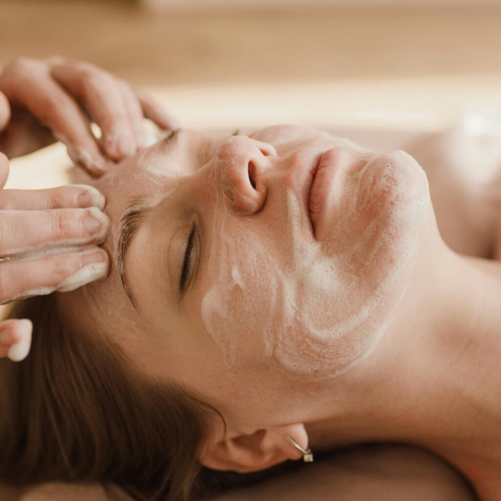 pexels-photo-6663368-6663368 A close-up of a woman receiving a soothing facial massage with a skincare mask.
